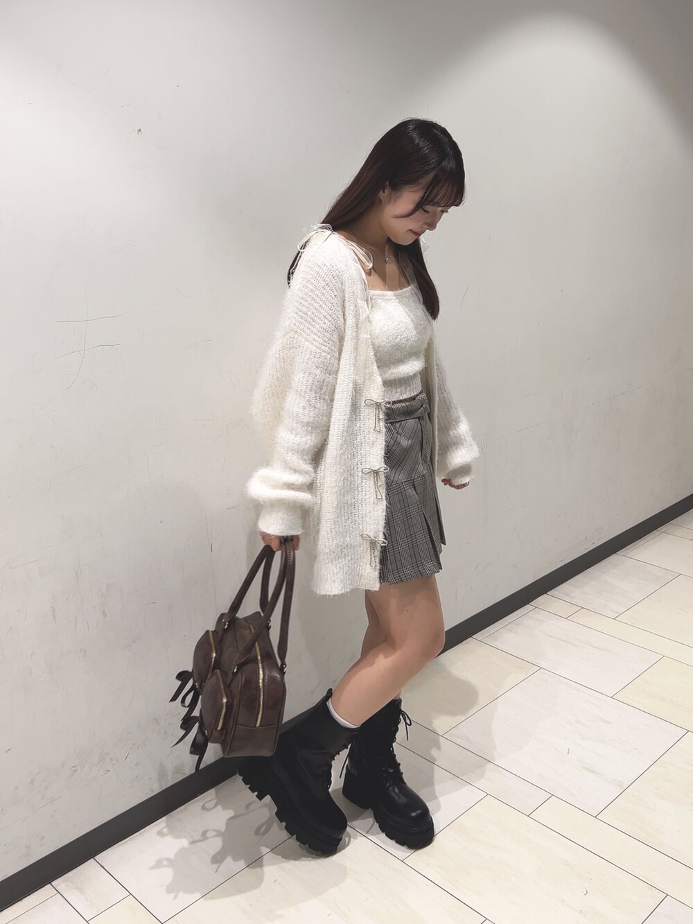 ホワイト系のアンサンブル、ホワイト系のカーディガン/ボレロ、ブラウン系のスカートを着用したレディースの秋コーディネートの4枚目の写真