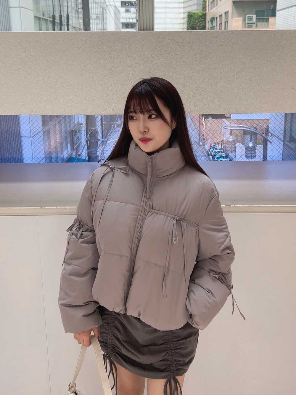 グレー系のダウンジャケット/コート、ホワイト系のTシャツ/カットソー、グレー系のスカートを着用したレディースの夏コーディネートの5枚目の写真