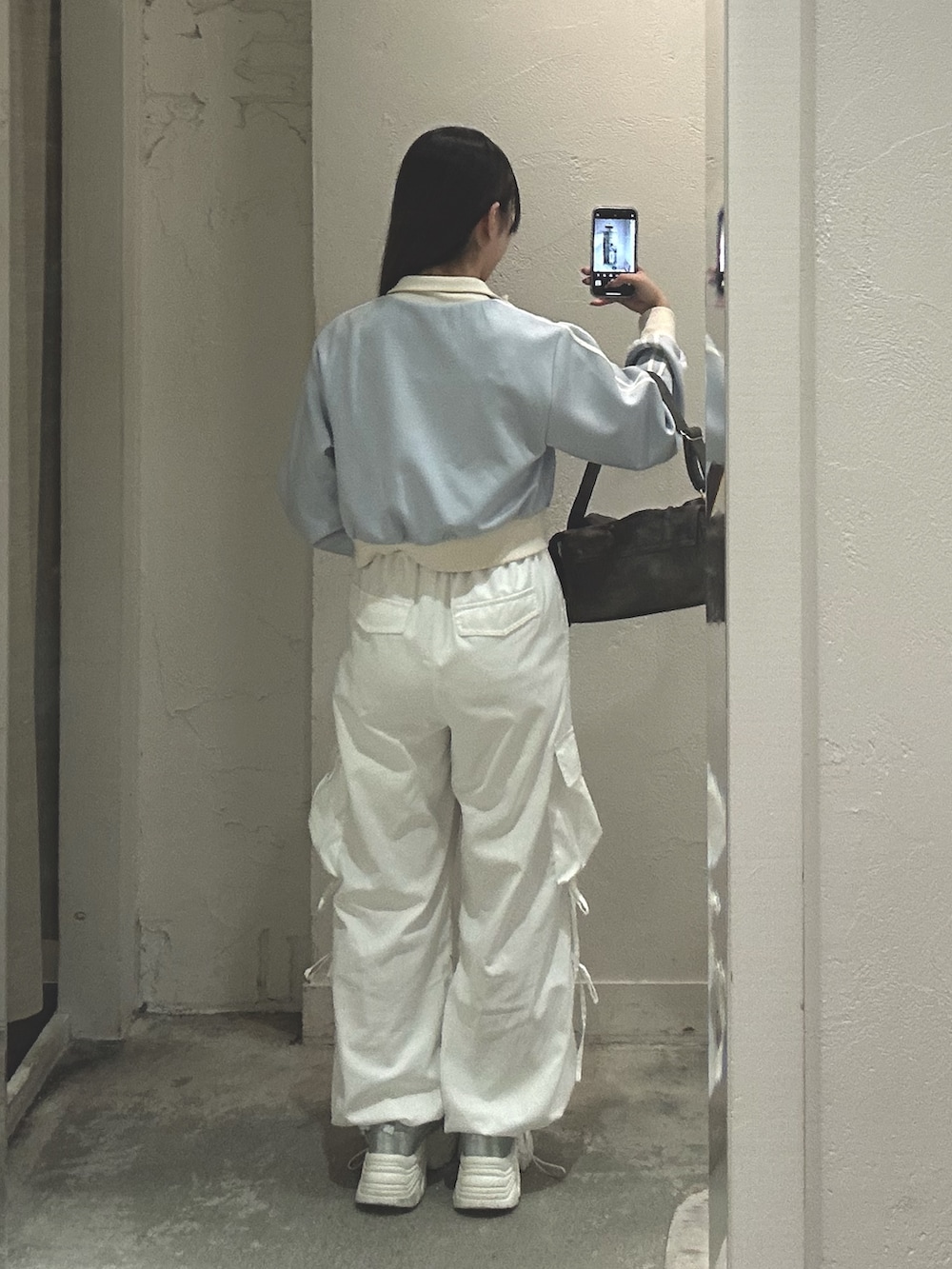 ブルー系のスウェット、ホワイト系のキャミソール、ブラック系のショルダーバッグを着用したレディースの夏コーディネートの2枚目の写真