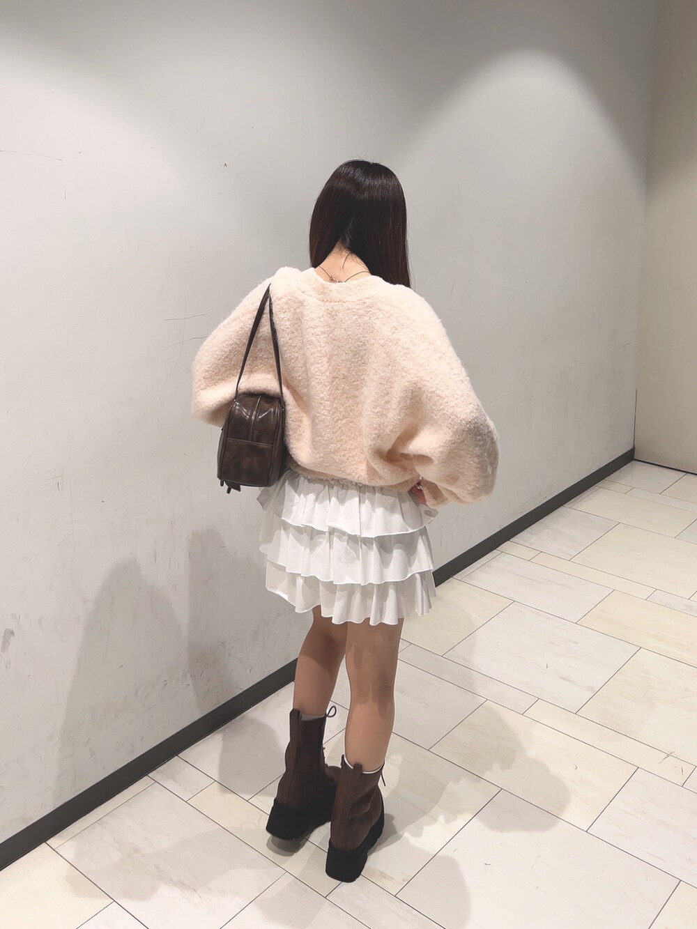 ピンク系のカーディガン/ボレロ、ホワイト系のアンサンブル、ホワイト系のスカートを着用したレディースの秋コーディネートの2枚目の写真