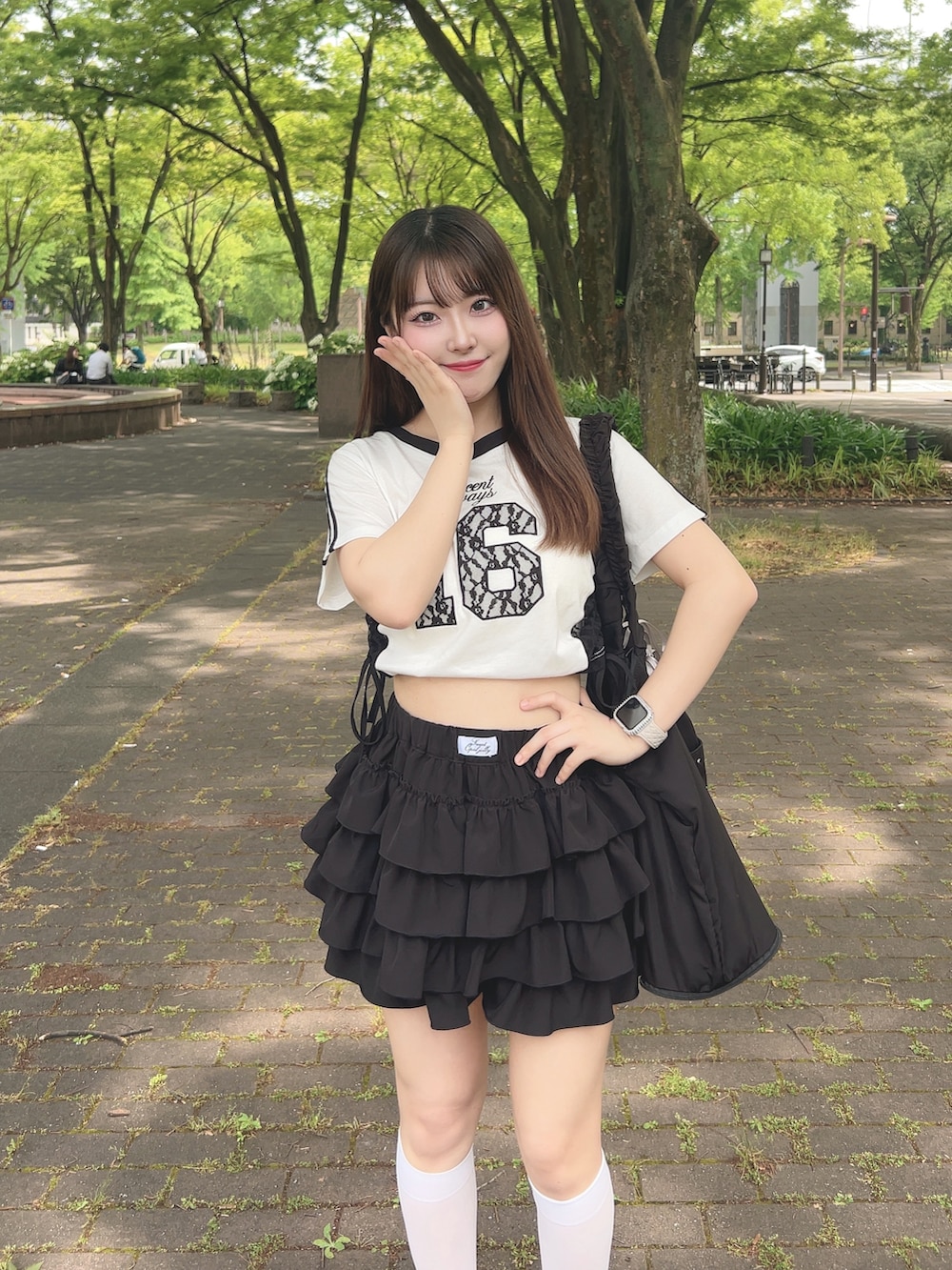 ホワイト系のTシャツ/カットソー、ブラック系のスカート、ブラック系のサンダルを着用したレディースの夏コーディネートの4枚目の写真