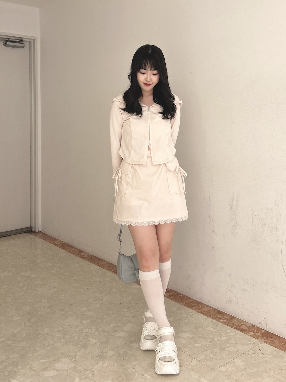 ピンク系のワンピース、ブルー系のショルダーバッグ、ホワイト系のサンダルを着用したレディースの春コーディネートの6枚目の写真