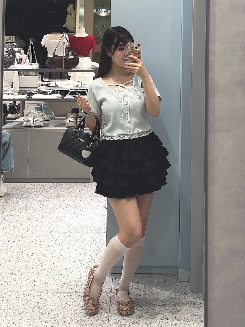 ブルー系のTシャツ/カットソー、ブラック系のスカート、ブラック系のボストンバッグを着用したレディースの夏コーディネートの3枚目の写真