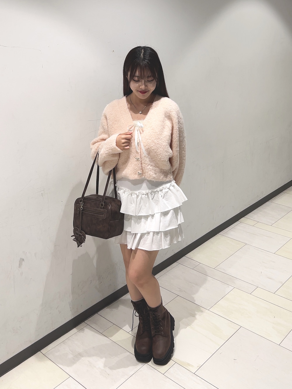 ピンク系のカーディガン/ボレロ、ホワイト系のアンサンブル、ホワイト系のスカートを着用したレディースの秋コーディネートの3枚目の写真