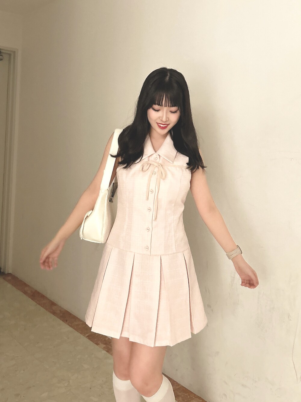 ピンク系のワンピース、ホワイト系のショルダーバッグ、ホワイト系のサンダルを着用したレディースの春コーディネートの5枚目の写真