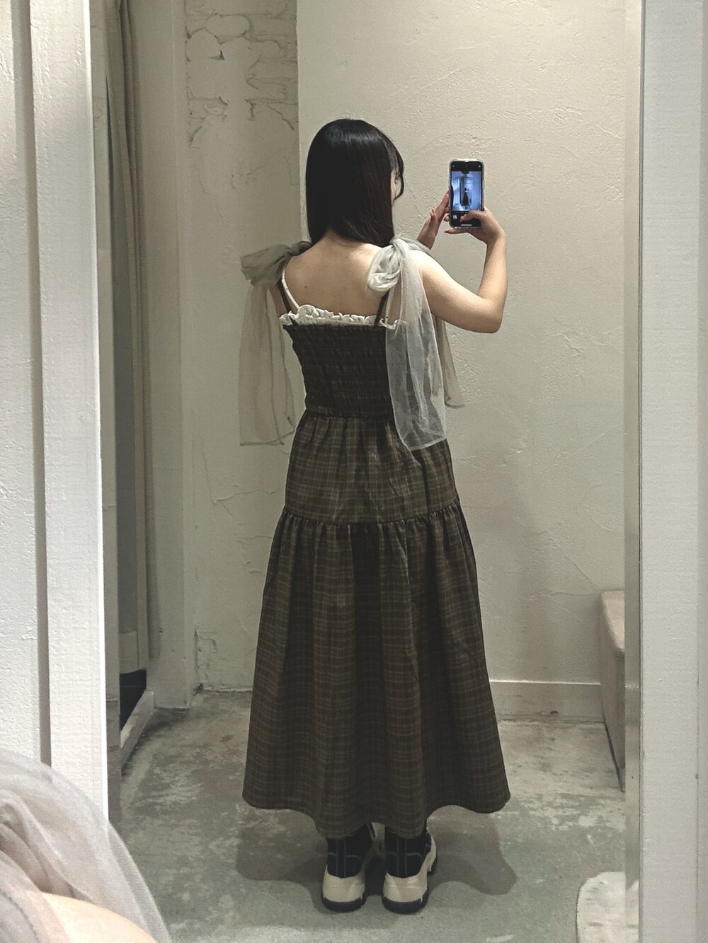 ブラウン系のワンピース、ホワイト系のショルダーバッグ、ブラック系のスニーカーを着用したレディースの夏コーディネートの2枚目の写真