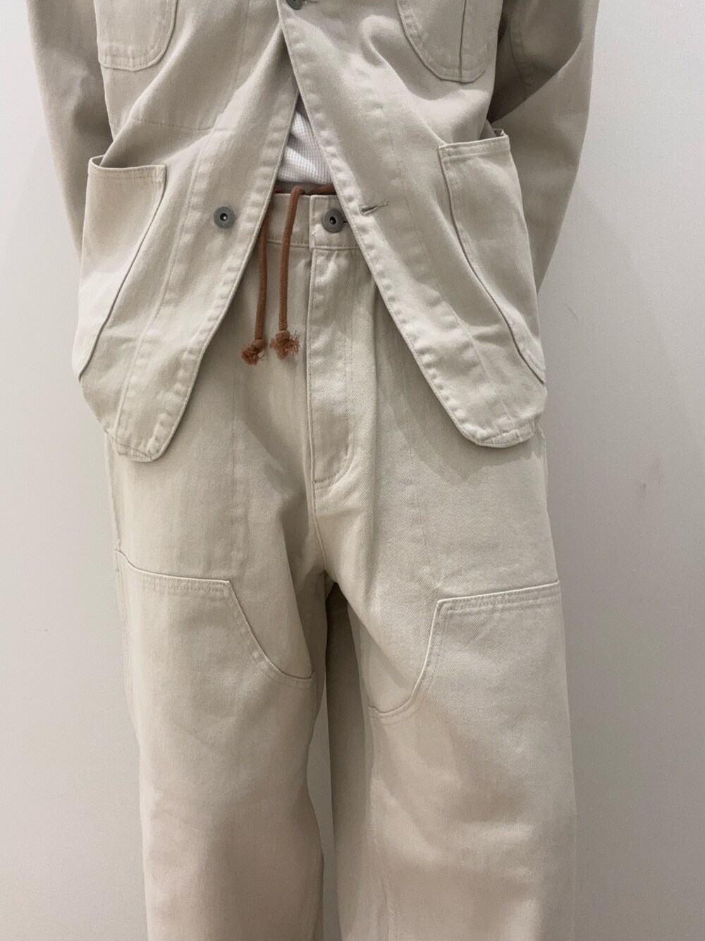 ベージュ系のジャケット/アウター、ブラウン系のスニーカー、ベージュ系のパンツを着用したメンズの夏コーディネートの3枚目の写真