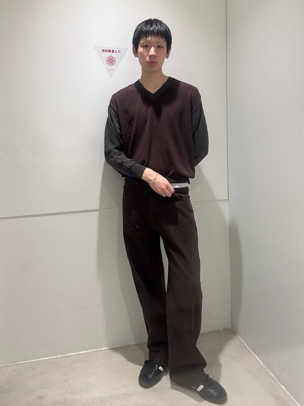 ブラウン系のニット/セーター、ブラウン系のデニムパンツ、ブラック系のスニーカーを着用したメンズの夏コーディネートの2枚目の写真