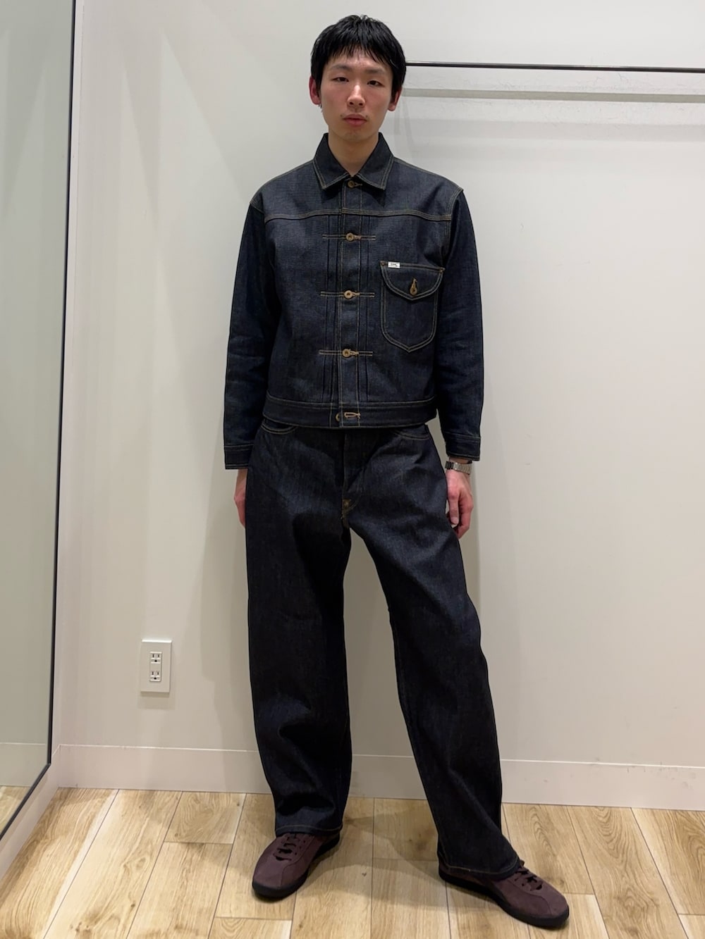 ブルー系のデニムジャケット、ブルー系のデニムパンツ、ブラウン系のスニーカーを着用したメンズの冬コーディネートの2枚目の写真