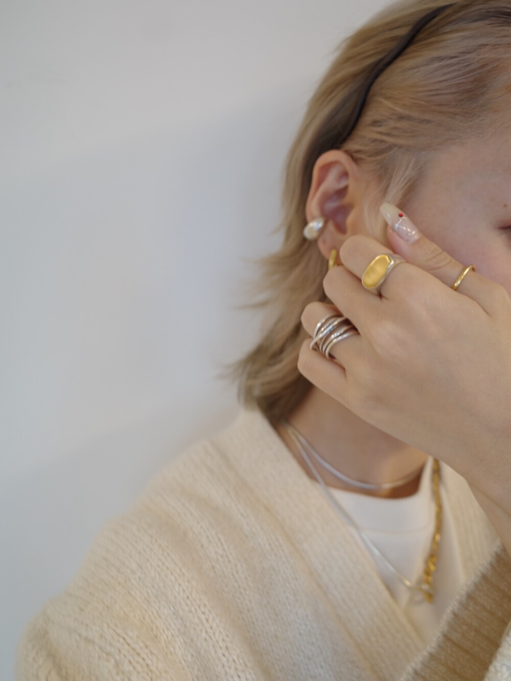 シルバー系のイヤーカフ、ゴールド系のピアス（両耳用）、シルバー系のネックレスを着用したレディースの秋コーディネートの3枚目の写真