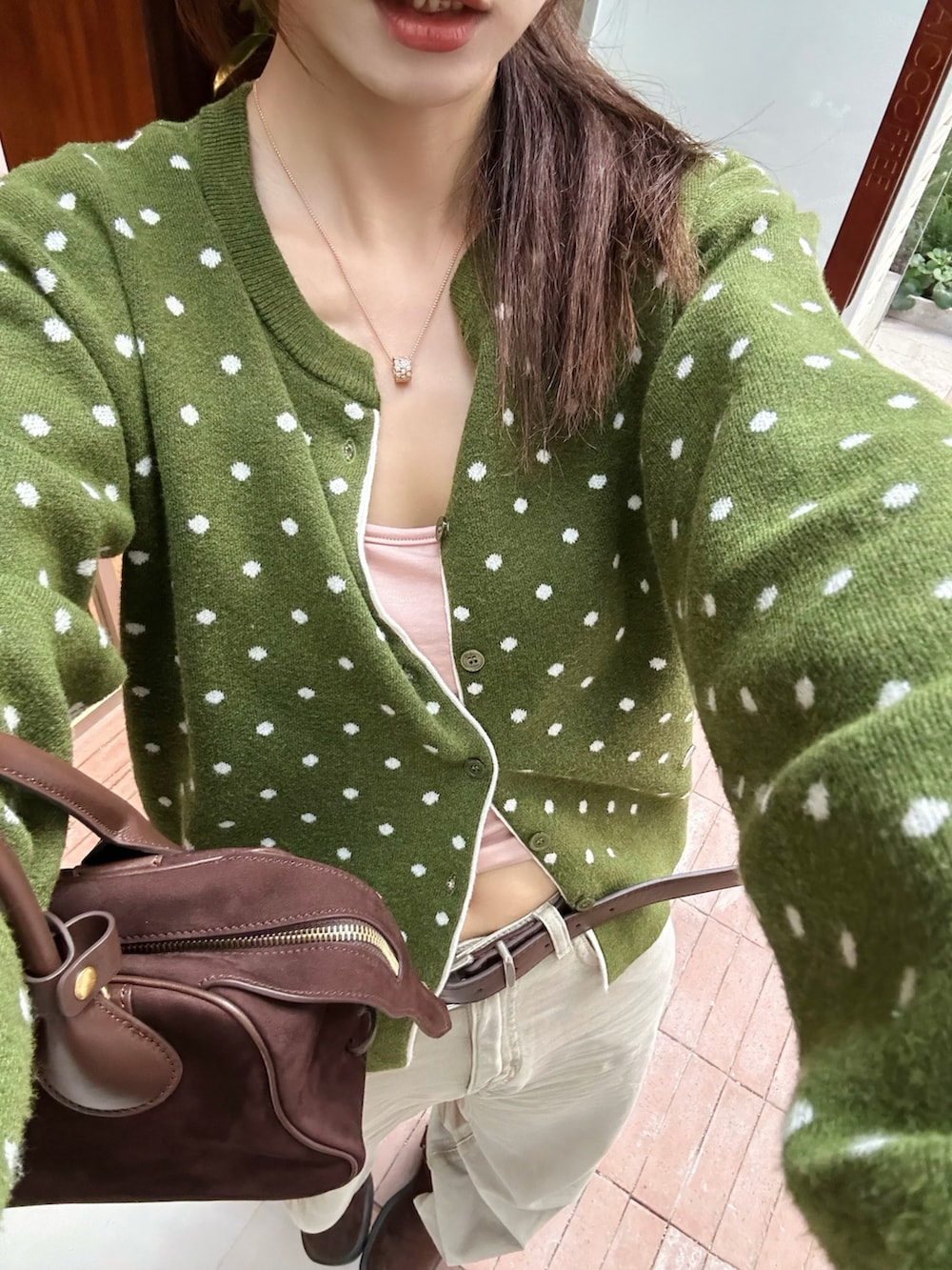 グリーン系のカーディガン/ボレロを着用したレディースの秋コーディネートの2枚目の写真