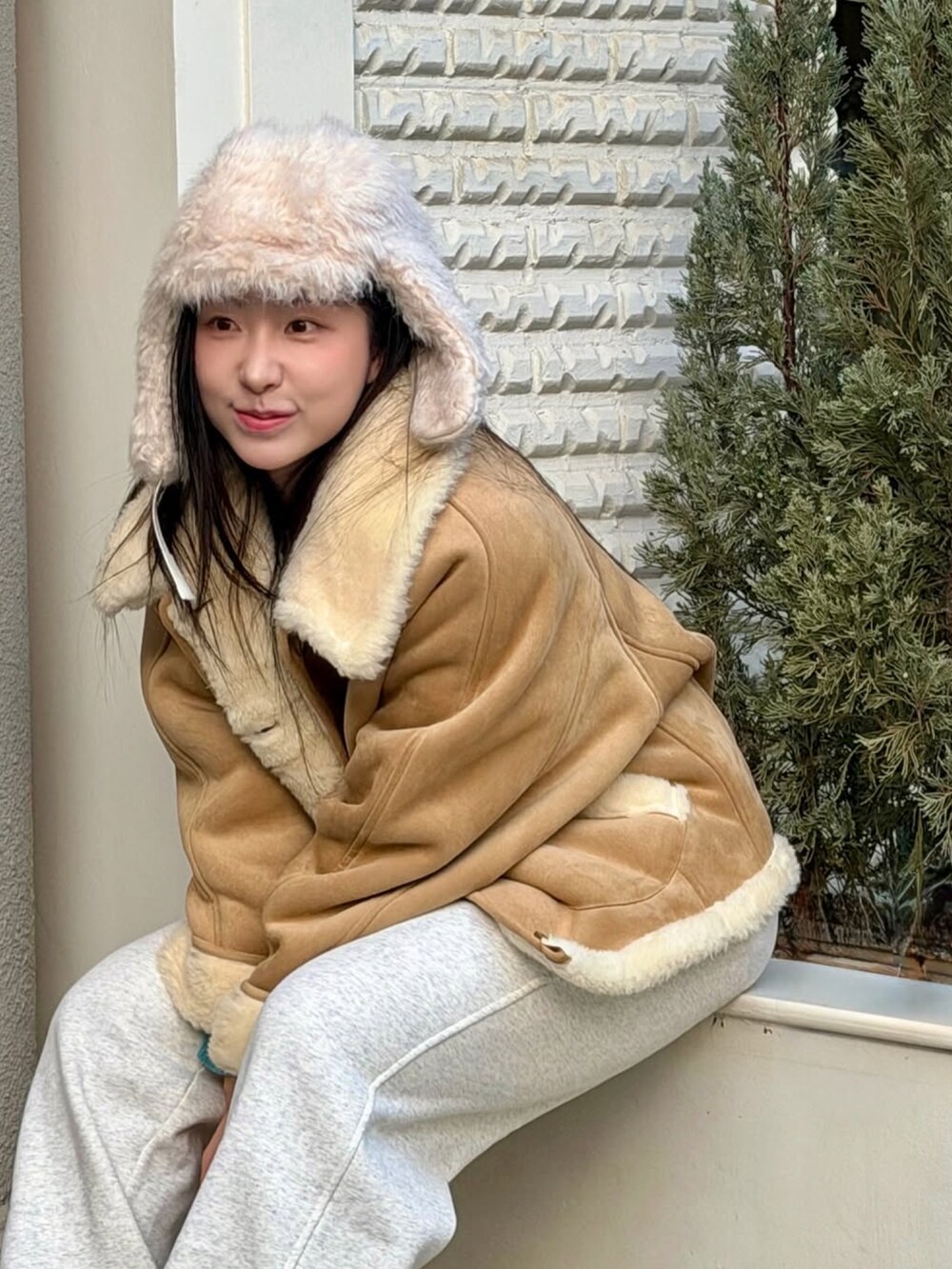 ベージュ系のムートンコートを着用したレディースの冬コーディネートの2枚目の写真