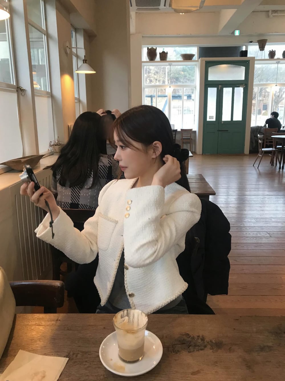 ホワイト系のノーカラージャケットを着用したレディースの冬コーディネートの2枚目の写真