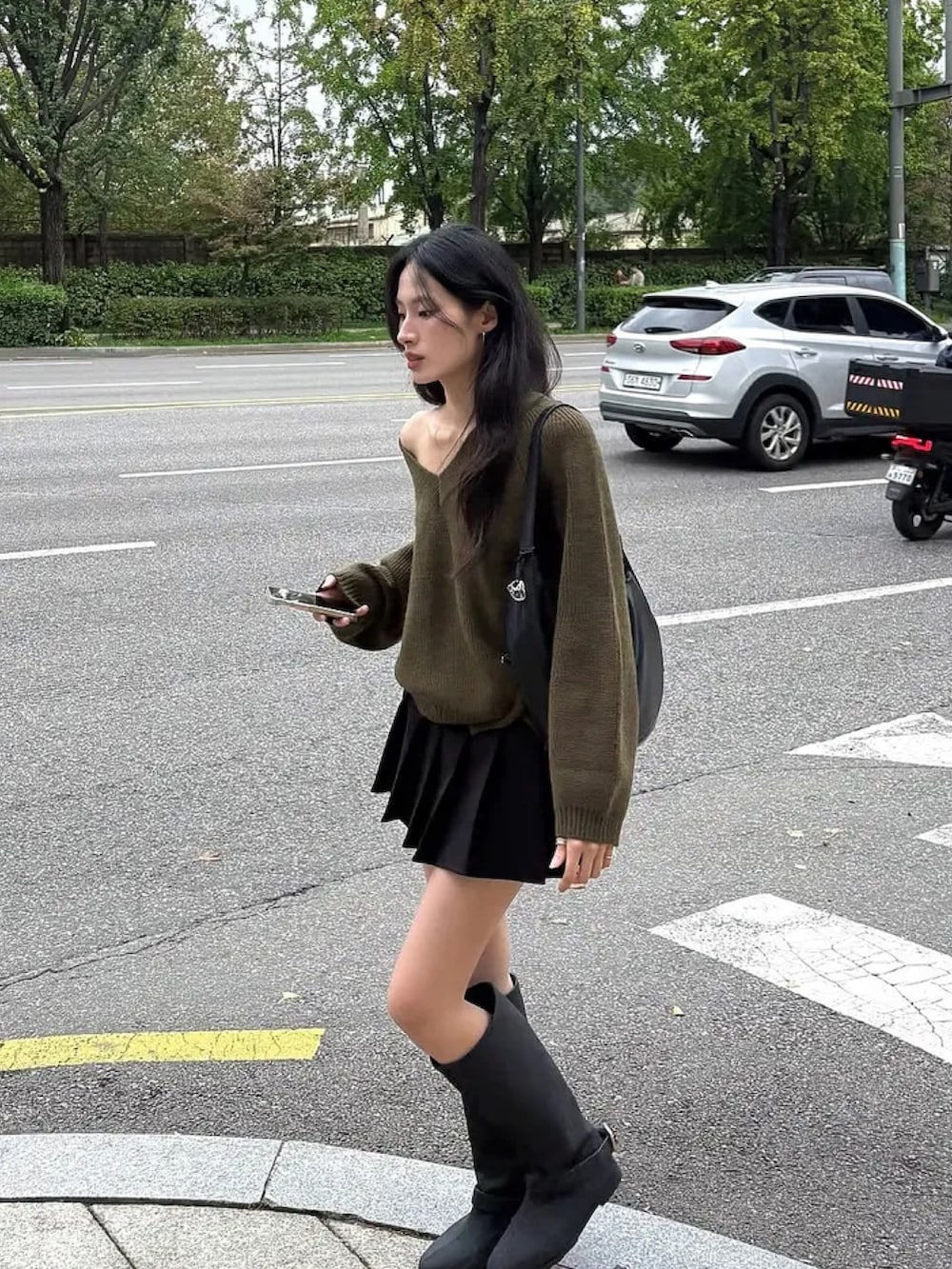 グリーン系のニット/セーターを着用したレディースの秋コーディネートの2枚目の写真