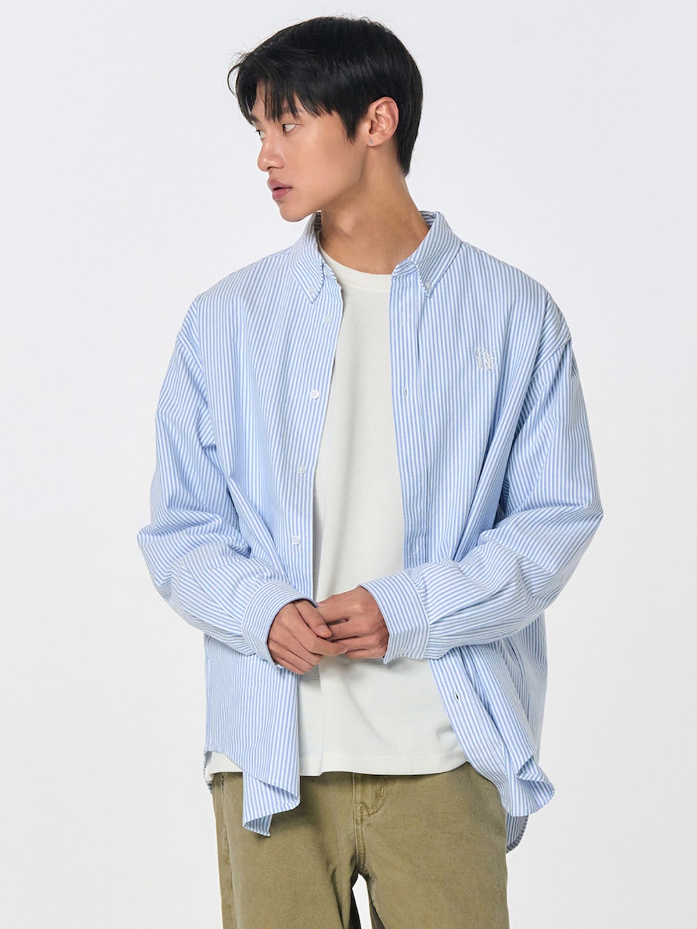 ブルー系のシャツ/ブラウス、ベージュ系のチノパンツを着用したレディースの冬コーディネートの2枚目の写真