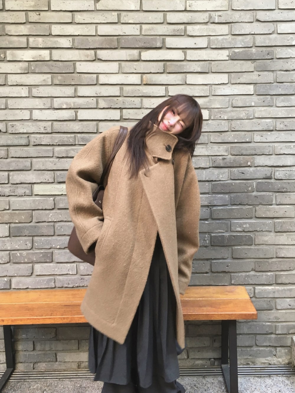 グリーン系のステンカラーコートを着用したレディースの冬コーディネートの2枚目の写真