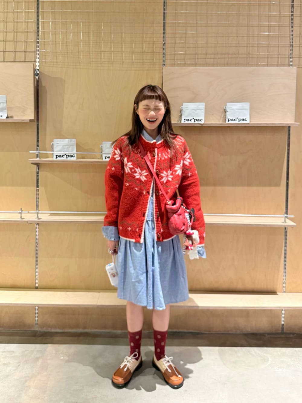 レッド系のカーディガン/ボレロを着用したレディースの冬コーディネートの2枚目の写真