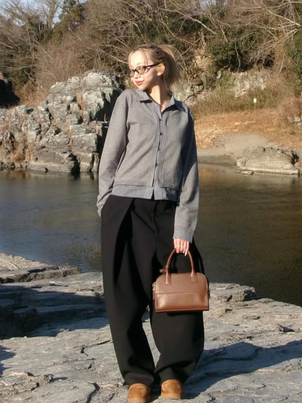 ブラウン系のハンドバッグを着用したレディースの冬コーディネートの2枚目の写真