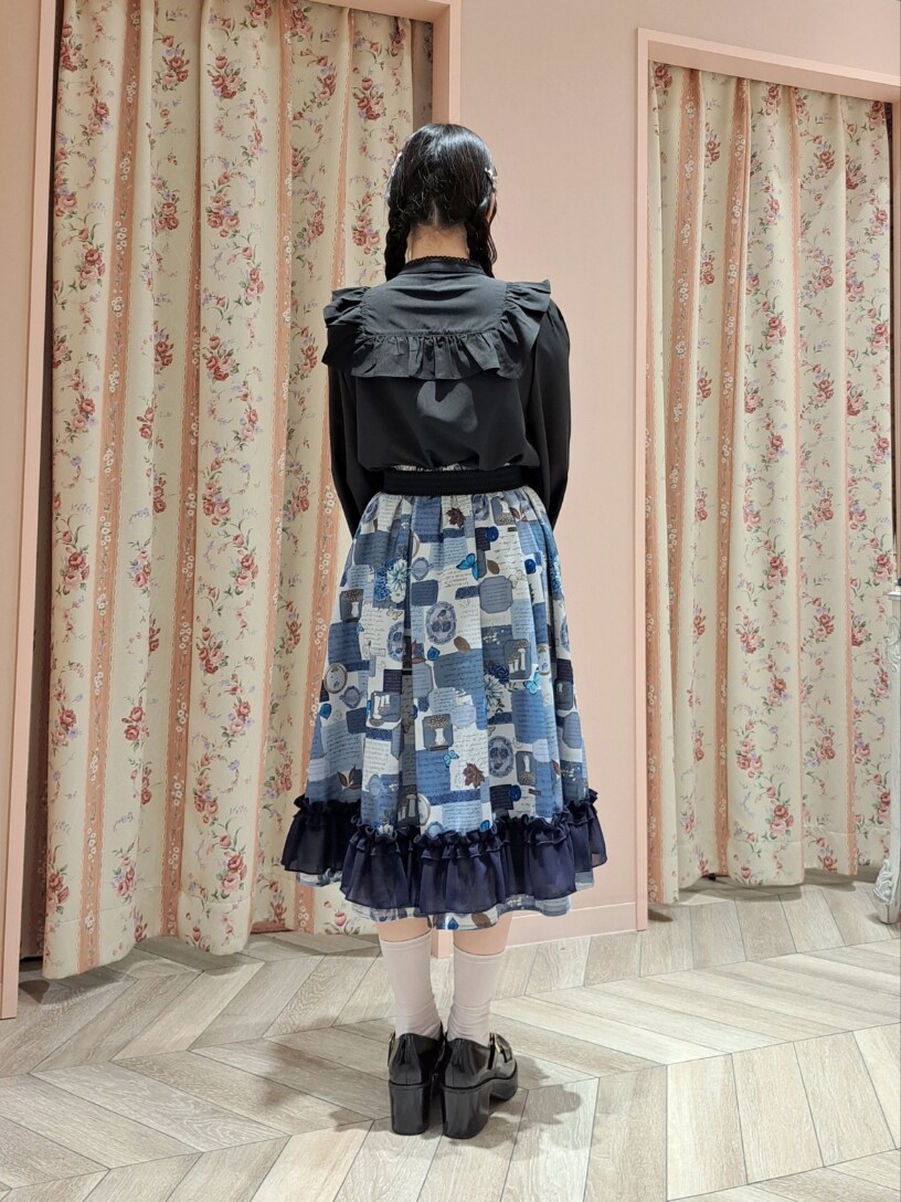 ブラック系のシャツ/ブラウス、ブルー系のスカート、ブラック系のローファーを着用したレディースの冬コーディネートの2枚目の写真