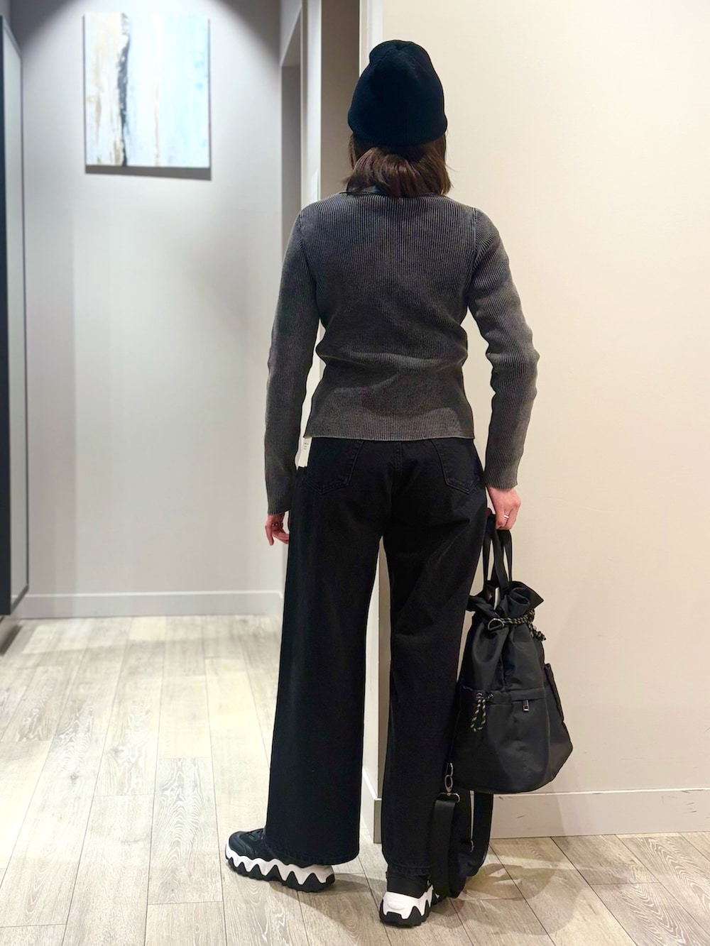 ブラック系のデニムパンツ、ブラック系のカーディガン/ボレロ、ホワイト系のTシャツ/カットソーを着用したレディースの冬コーディネートの3枚目の写真