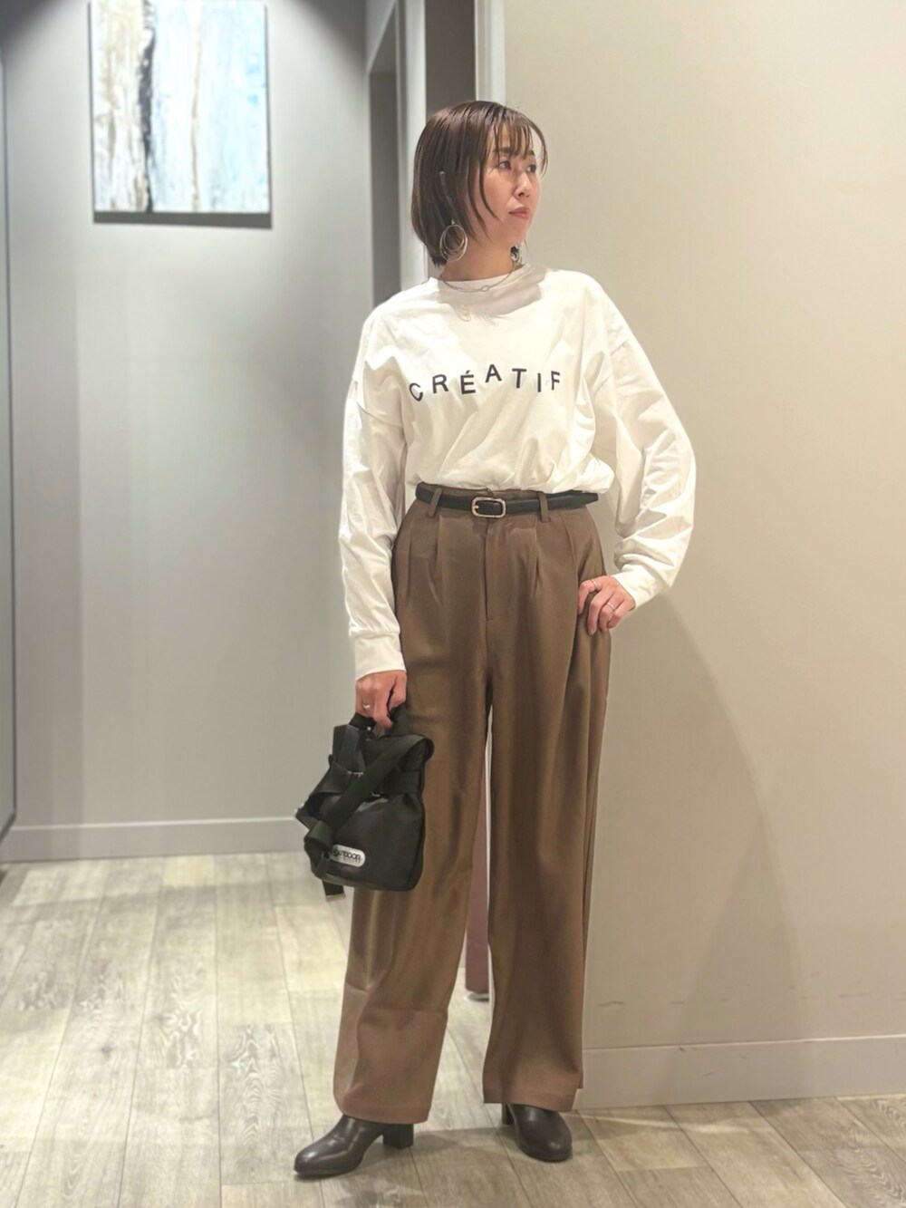 ブラウン系のその他パンツ、ホワイト系のTシャツ/カットソー、ブラック系のチェスターコートを着用したレディースの秋コーディネートの5枚目の写真