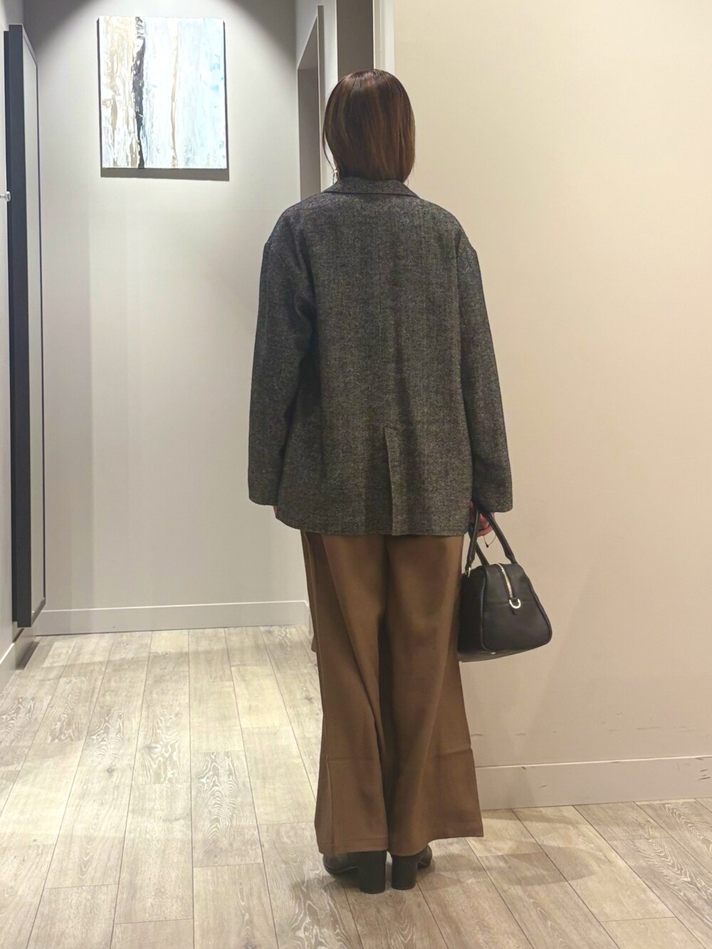 ブラウン系のその他パンツ、ホワイト系のTシャツ/カットソー、ブラック系のチェスターコートを着用したレディースの秋コーディネートの3枚目の写真