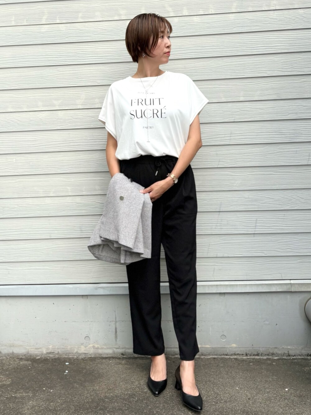 ベージュ系のノーカラージャケット、ブラック系のその他パンツ、シルバー系のネックレスを着用したレディースの夏コーディネートの5枚目の写真