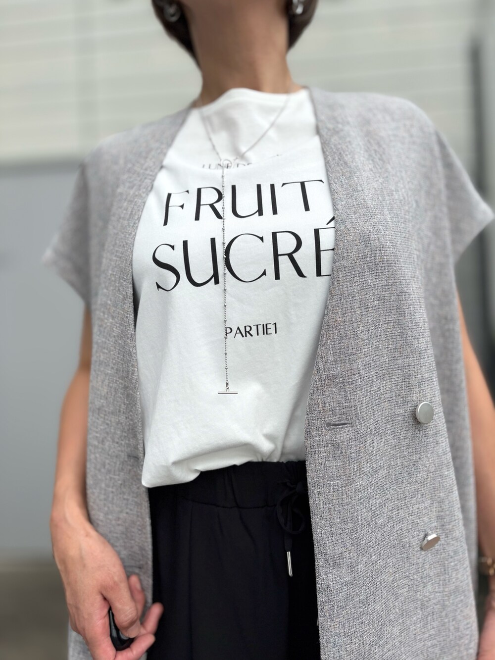 ベージュ系のノーカラージャケット、ブラック系のその他パンツ、シルバー系のネックレスを着用したレディースの夏コーディネートの3枚目の写真