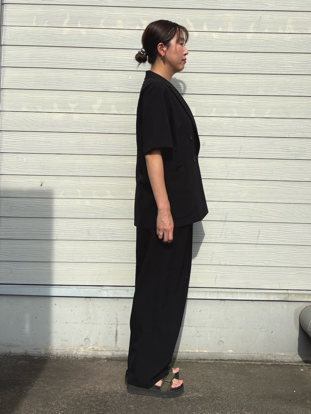 ブラック系のその他パンツ、ブラック系のテーラードジャケット、ベージュ系のキャミソールを着用したレディースの夏コーディネートの2枚目の写真