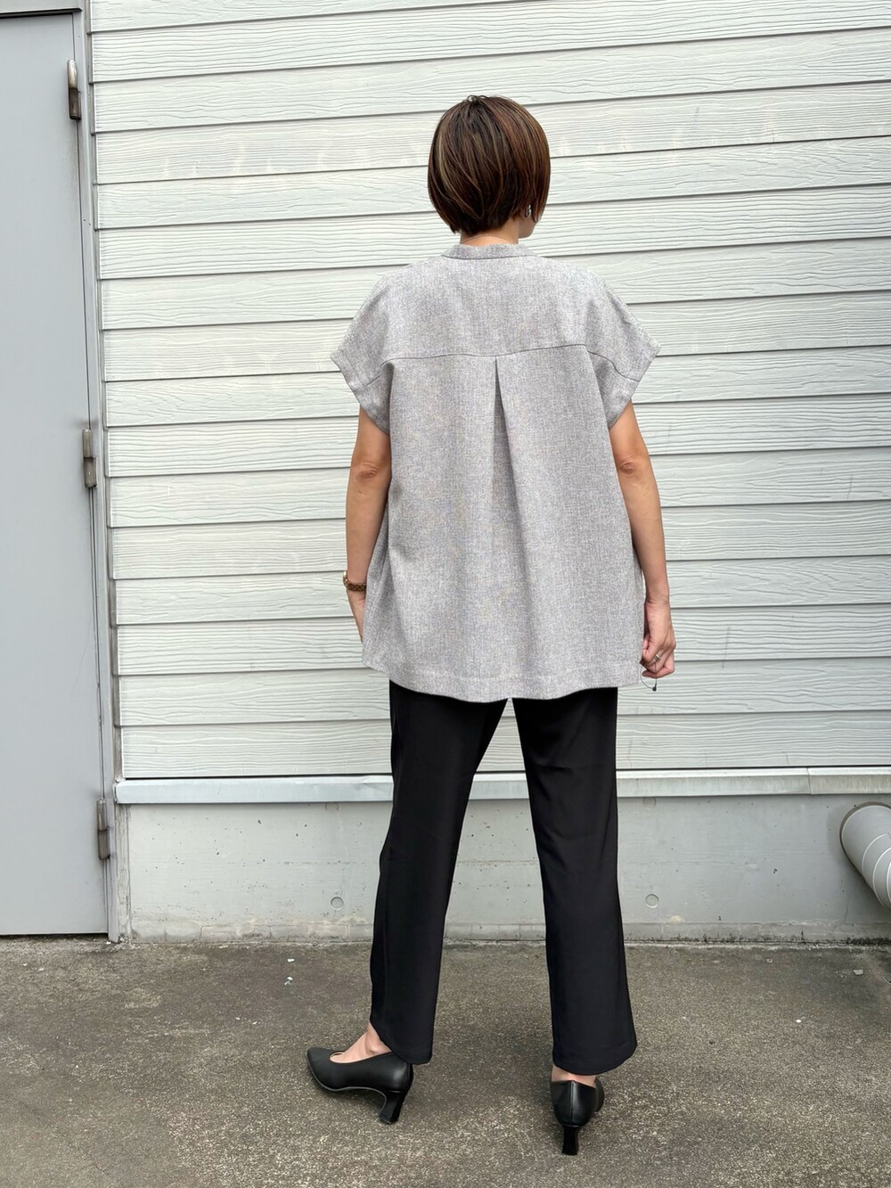 ベージュ系のノーカラージャケット、ブラック系のその他パンツ、シルバー系のネックレスを着用したレディースの夏コーディネートの4枚目の写真