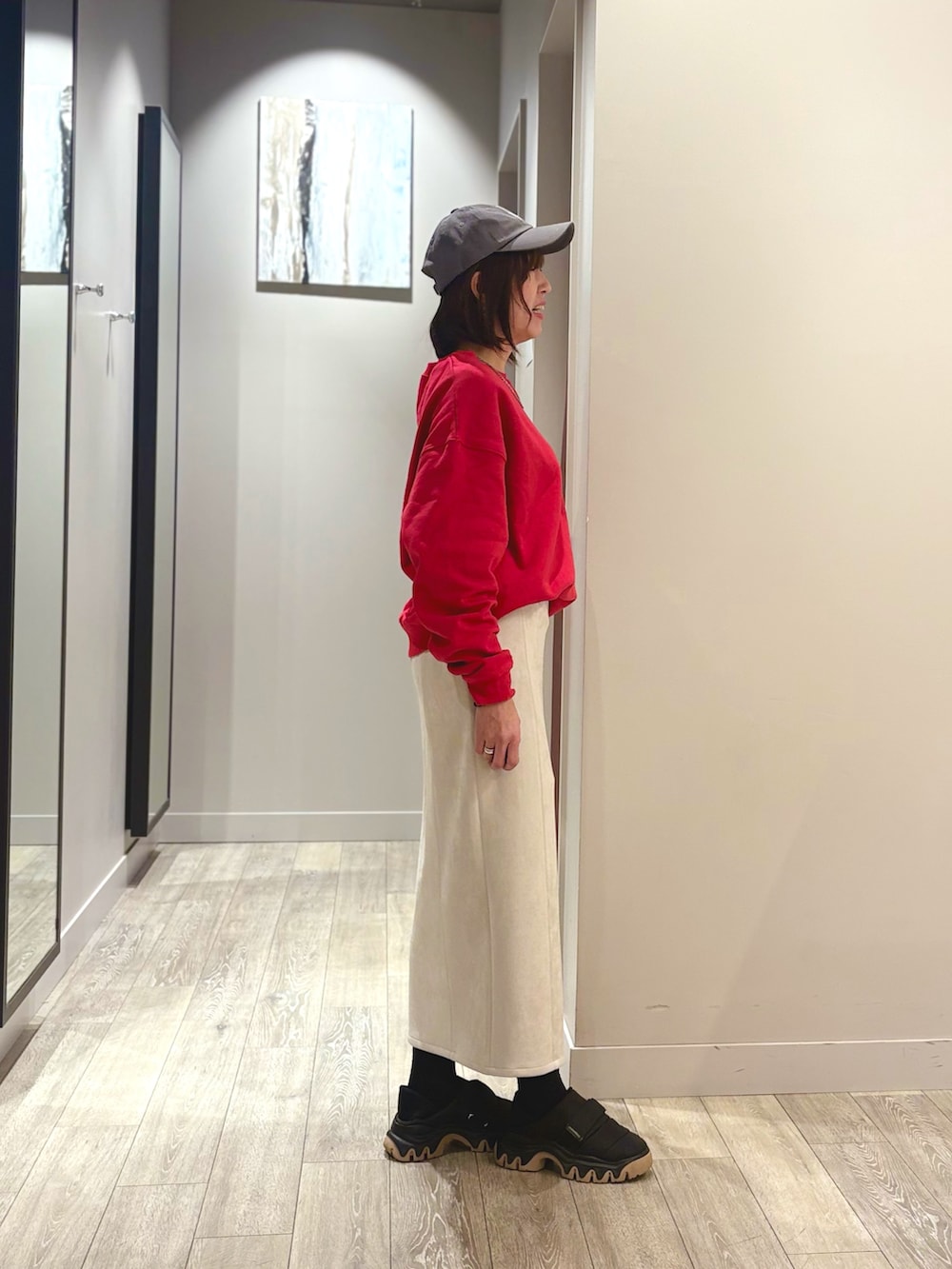 グレー系のダウンジャケット/コート、レッド系のスウェット、ホワイト系のスカートを着用したレディースの冬コーディネートの3枚目の写真