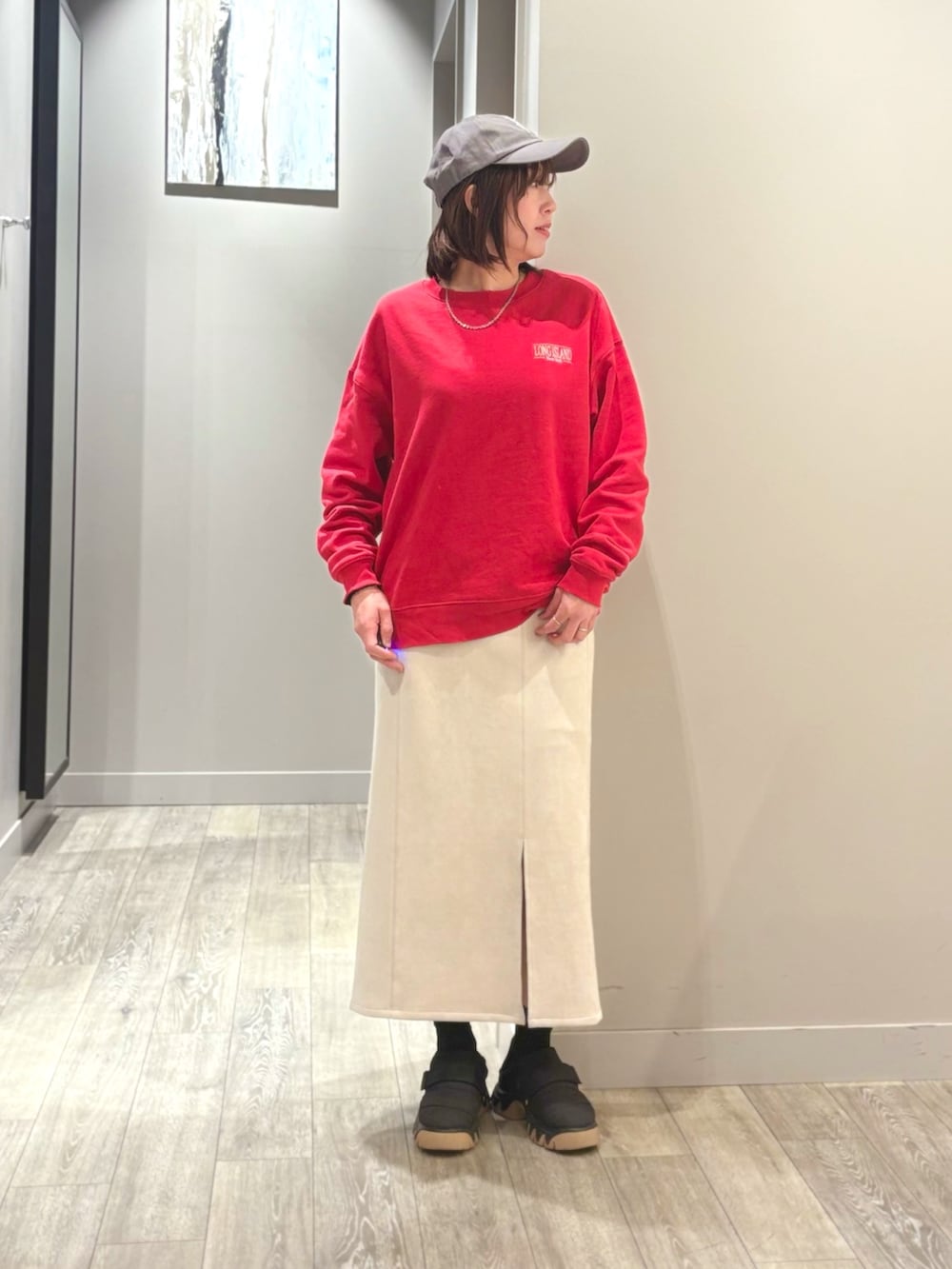 グレー系のダウンジャケット/コート、レッド系のスウェット、ホワイト系のスカートを着用したレディースの冬コーディネートの4枚目の写真