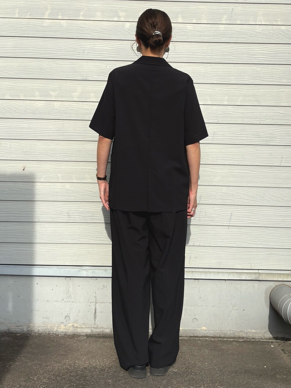 ブラック系のその他パンツ、ブラック系のテーラードジャケット、ベージュ系のキャミソールを着用したレディースの夏コーディネートの3枚目の写真