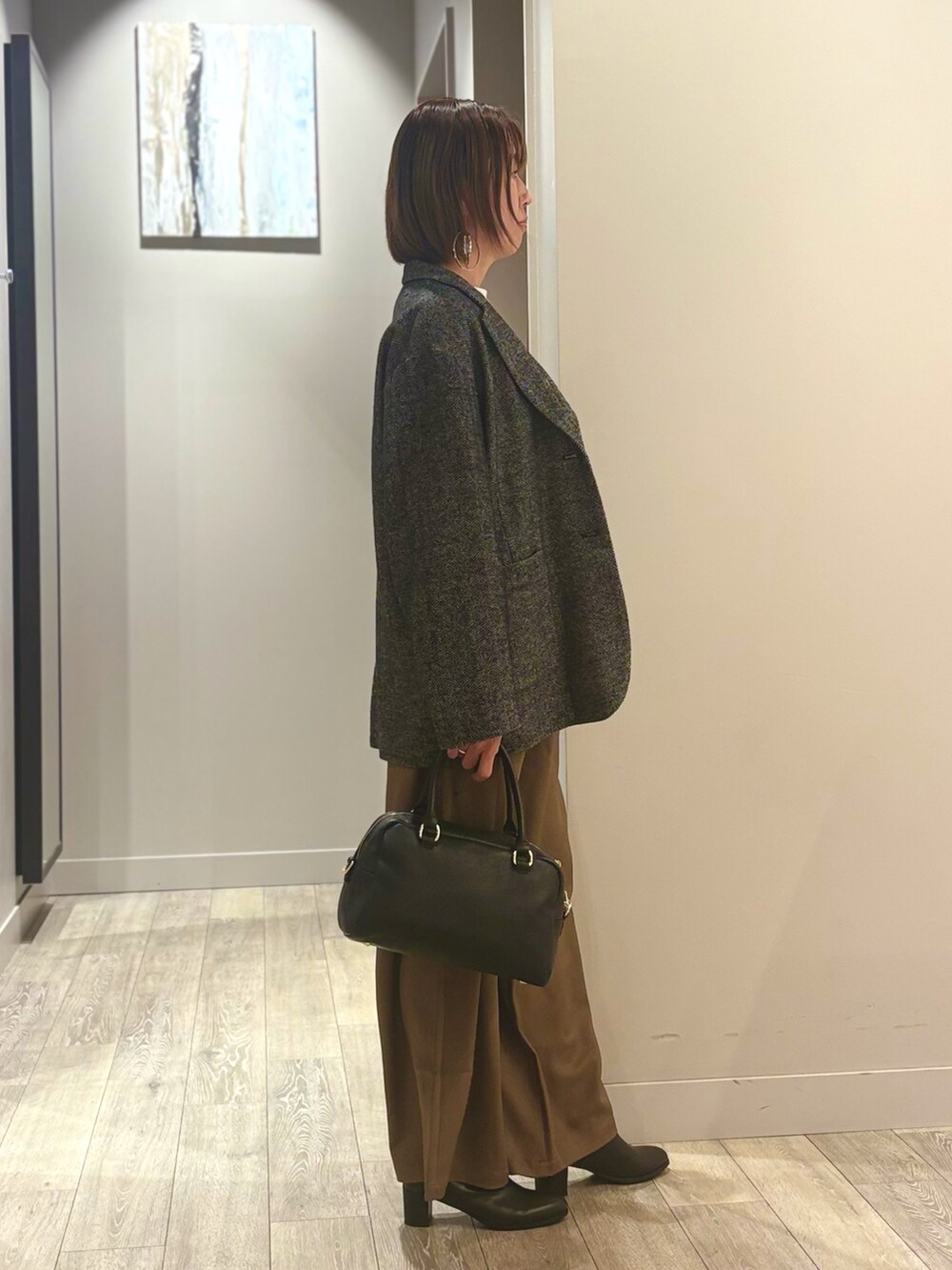 ブラウン系のその他パンツ、ホワイト系のTシャツ/カットソー、ブラック系のチェスターコートを着用したレディースの秋コーディネートの2枚目の写真