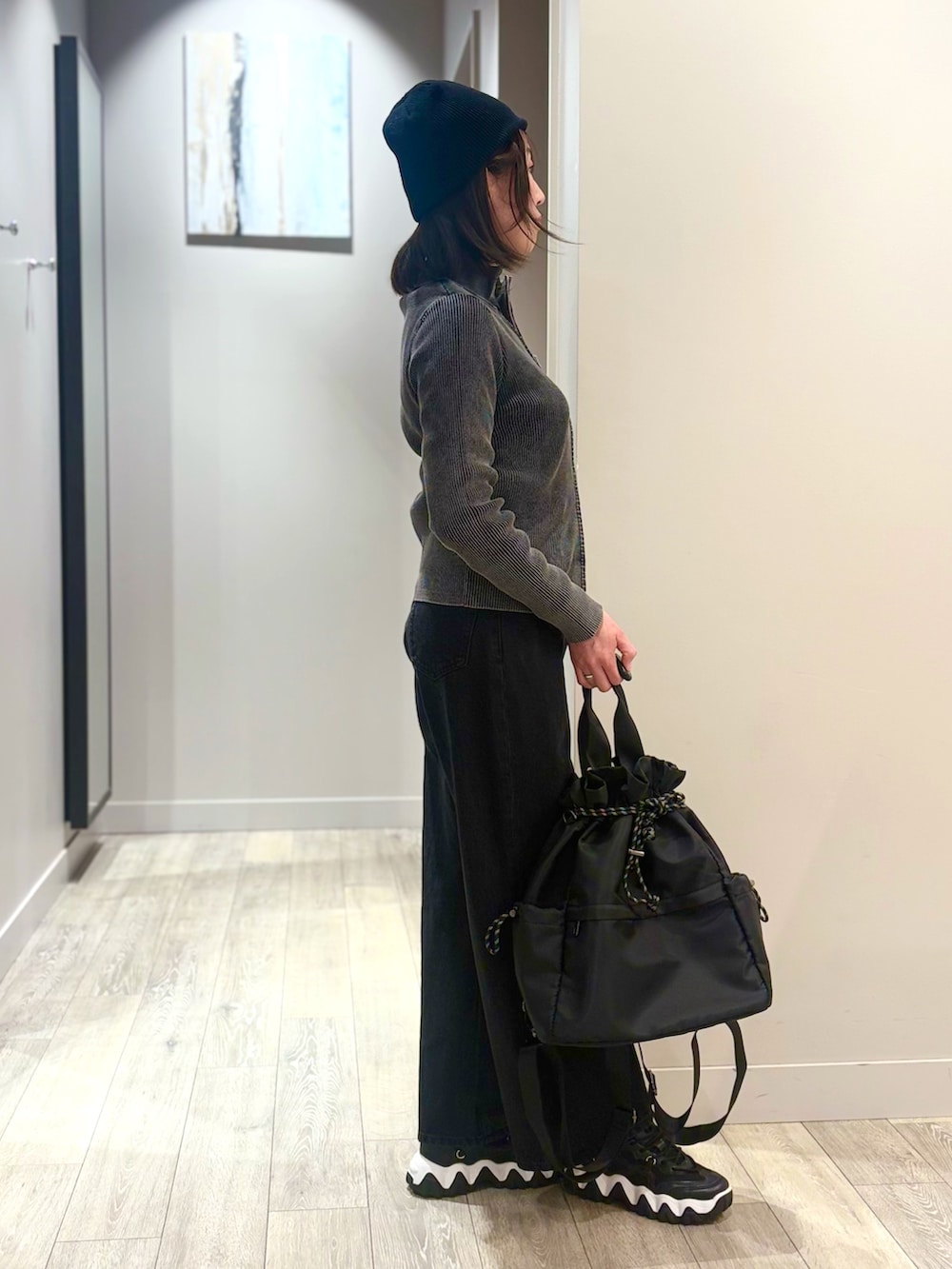 ブラック系のデニムパンツ、ブラック系のカーディガン/ボレロ、ホワイト系のTシャツ/カットソーを着用したレディースの冬コーディネートの2枚目の写真