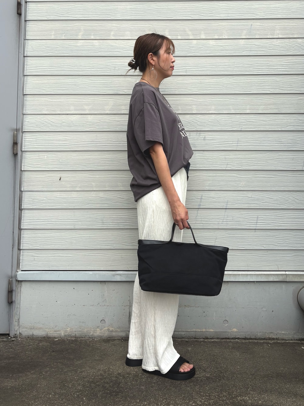 グレー系のTシャツ/カットソー、ホワイト系のその他パンツ、ブラック系のトートバッグを着用したレディースの夏コーディネートの2枚目の写真