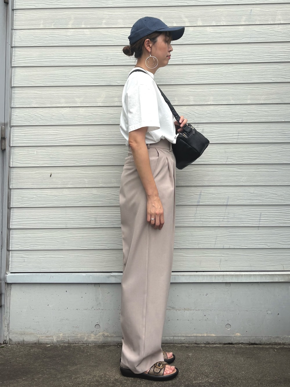 ベージュ系のスラックス、ホワイト系のTシャツ/カットソーを着用したレディースの夏コーディネートの2枚目の写真