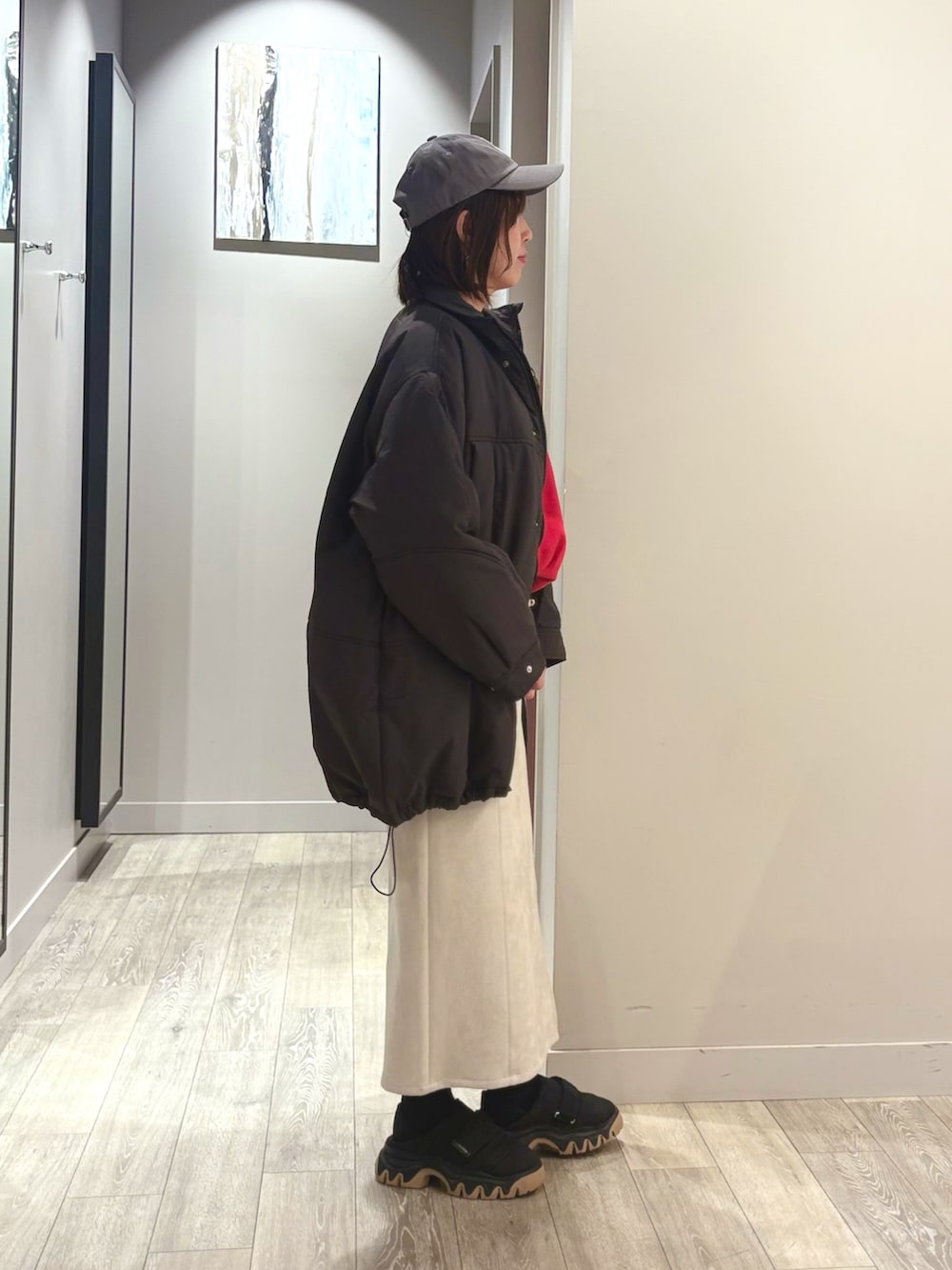 グレー系のダウンジャケット/コート、レッド系のスウェット、ホワイト系のスカートを着用したレディースの冬コーディネートの2枚目の写真