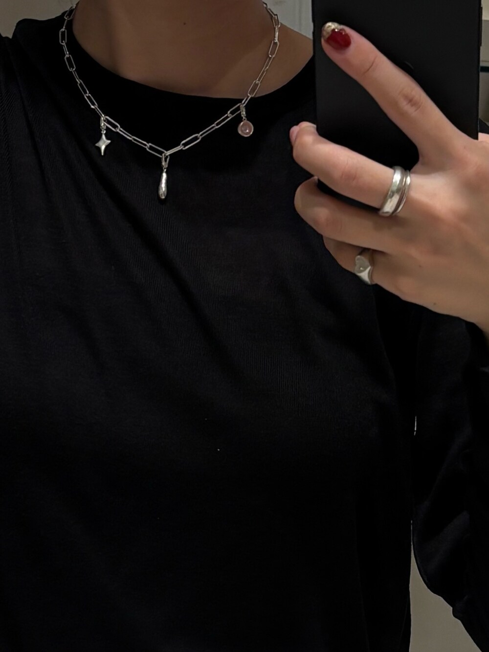 シルバー系のネックレス、ピンク系のチャーム、シルバー系のチャームを着用したレディースの秋コーディネートの2枚目の写真