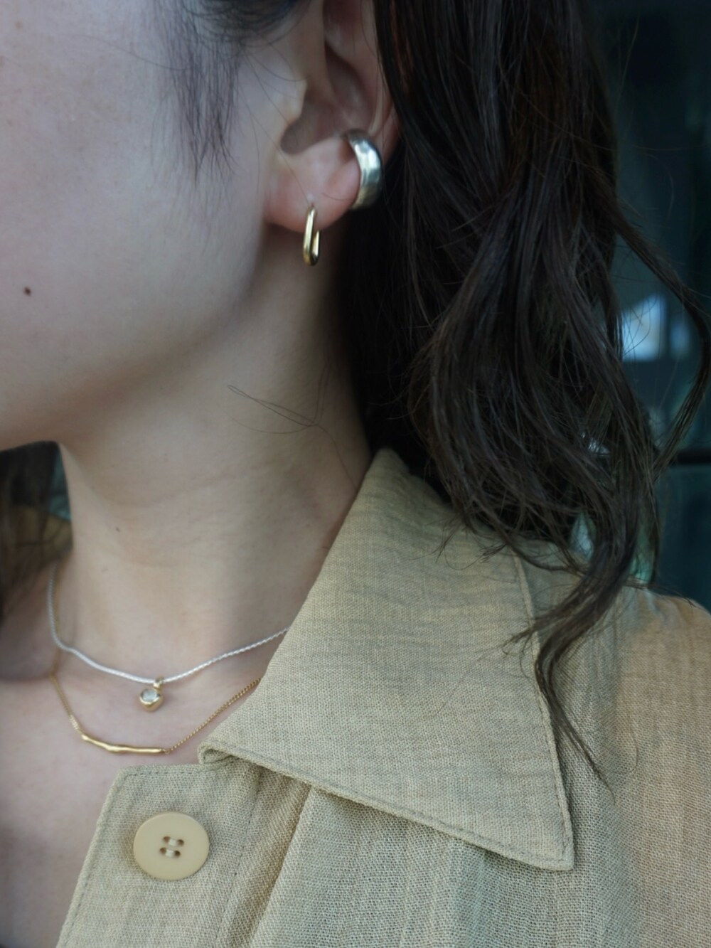 シルバー系のブレスレット、ベージュ系のリング、ゴールド系のネックレスを着用したレディースの夏コーディネートの4枚目の写真