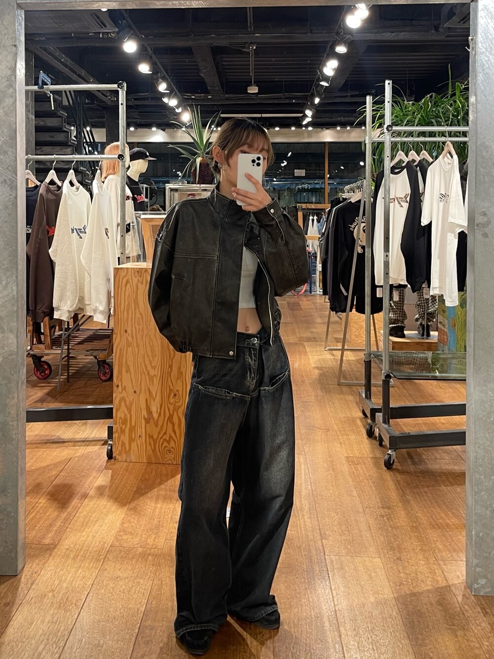 ブラック系のブルゾン、ブルー系のデニムパンツ、ホワイト系のシャツ/ブラウスを着用したレディースの秋コーディネートの3枚目の写真