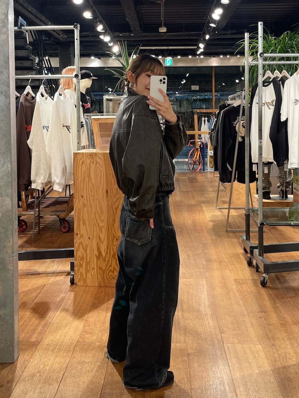 ブラック系のブルゾン、ブルー系のデニムパンツ、ホワイト系のシャツ/ブラウスを着用したレディースの秋コーディネートの2枚目の写真