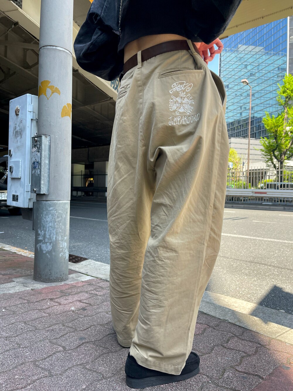 ブラック系のデニムジャケット、ベージュ系のチノパンツ、シルバー系のショルダーバッグを着用したレディースの春コーディネートの3枚目の写真