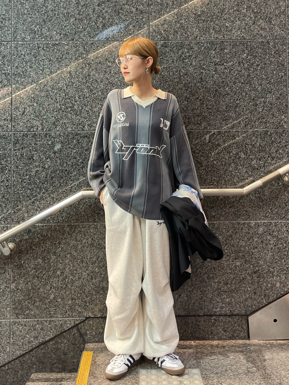 ブラック系のテーラードジャケット、グレー系のニット/セーター、グレー系のパンツを着用したレディースの秋コーディネートの3枚目の写真