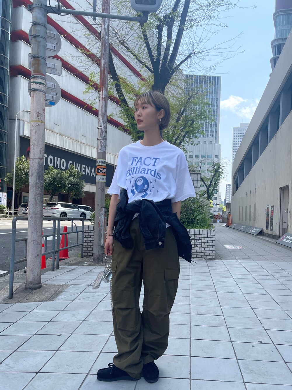 グリーン系のカーゴパンツ、ホワイト系のTシャツ/カットソー、ブラック系のデニムジャケットを着用したレディースの春コーディネートの3枚目の写真