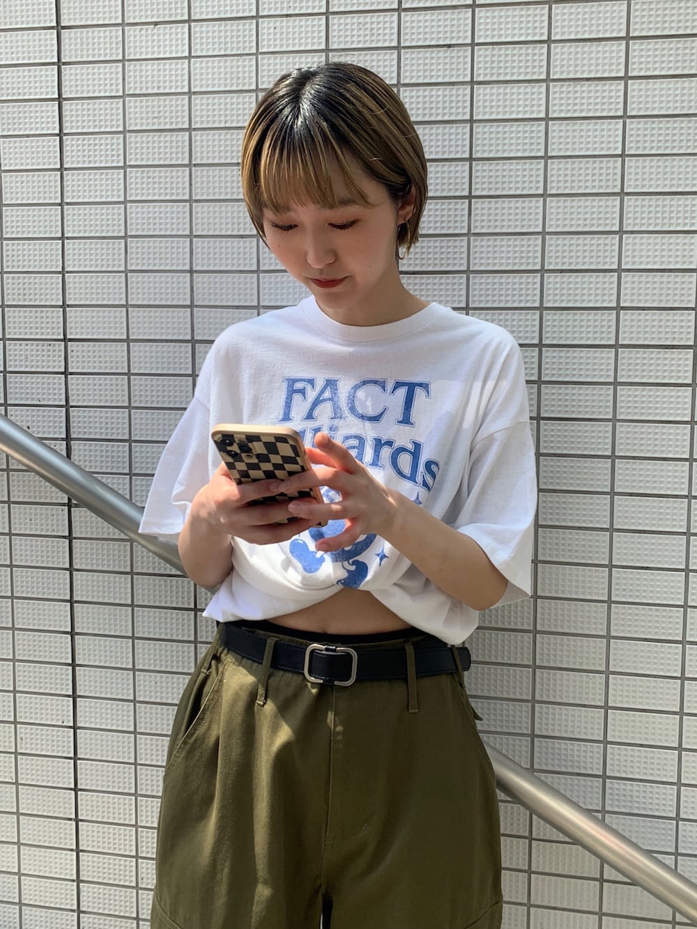 グリーン系のカーゴパンツ、ホワイト系のTシャツ/カットソー、ブラック系のデニムジャケットを着用したレディースの春コーディネートの2枚目の写真