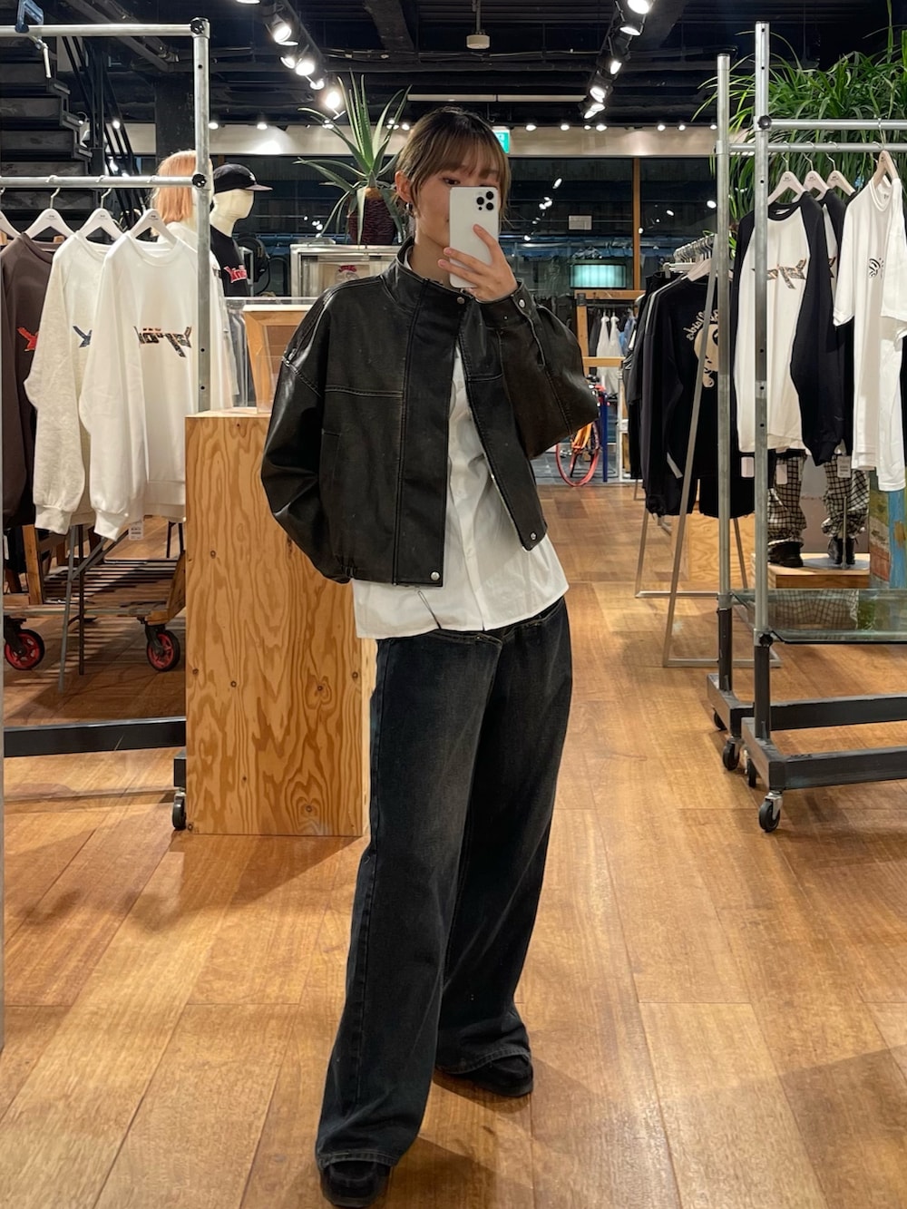 ブラック系のブルゾン、ブルー系のデニムパンツ、ホワイト系のシャツ/ブラウスを着用したレディースの秋コーディネートの4枚目の写真
