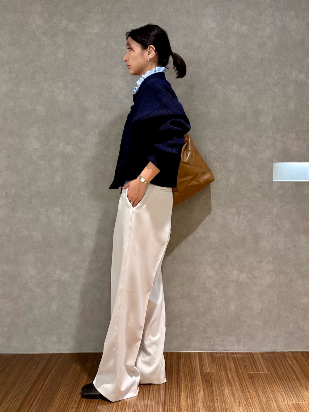ブルー系のカーディガン/ボレロ、ベージュ系のその他パンツ、ブラウン系のハンドバッグを着用したレディースの冬コーディネートの2枚目の写真