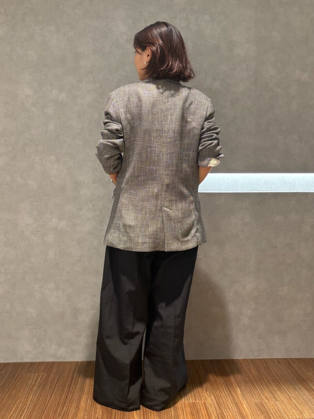 ブラック系のニット/セーター、グレー系のテーラードジャケット、ブラック系のその他パンツを着用したレディースの秋コーディネートの4枚目の写真