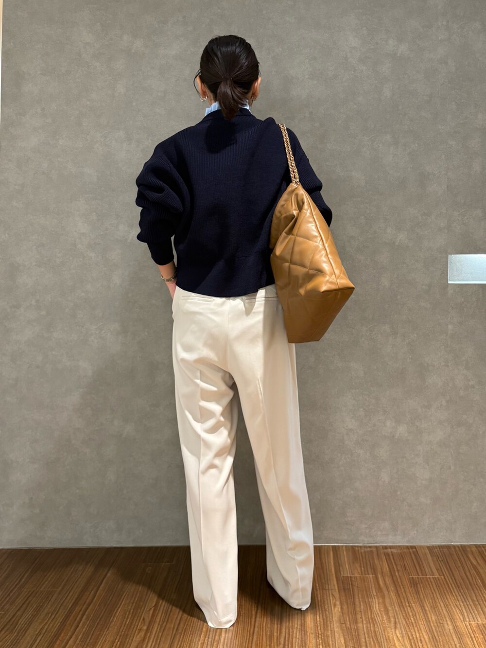 ブルー系のカーディガン/ボレロ、ベージュ系のその他パンツ、ブラウン系のハンドバッグを着用したレディースの冬コーディネートの3枚目の写真